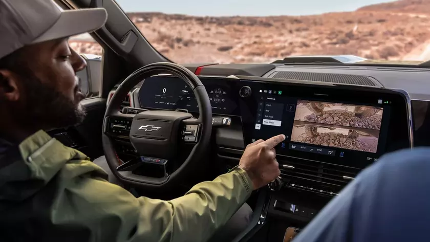 Водитель касается сенсорного экрана нового инфотейнмента Chevrolet Silverado