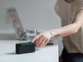 post_big/woman-reaching-for-black-bluetooth-speaker-on-top-of-white-374056.jpg