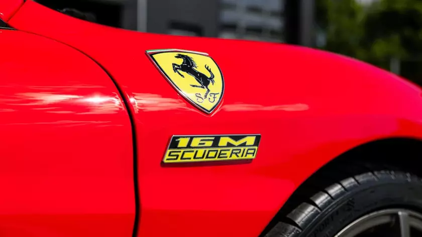 Красная Ferrari Scuderia Spider 16M на дороге