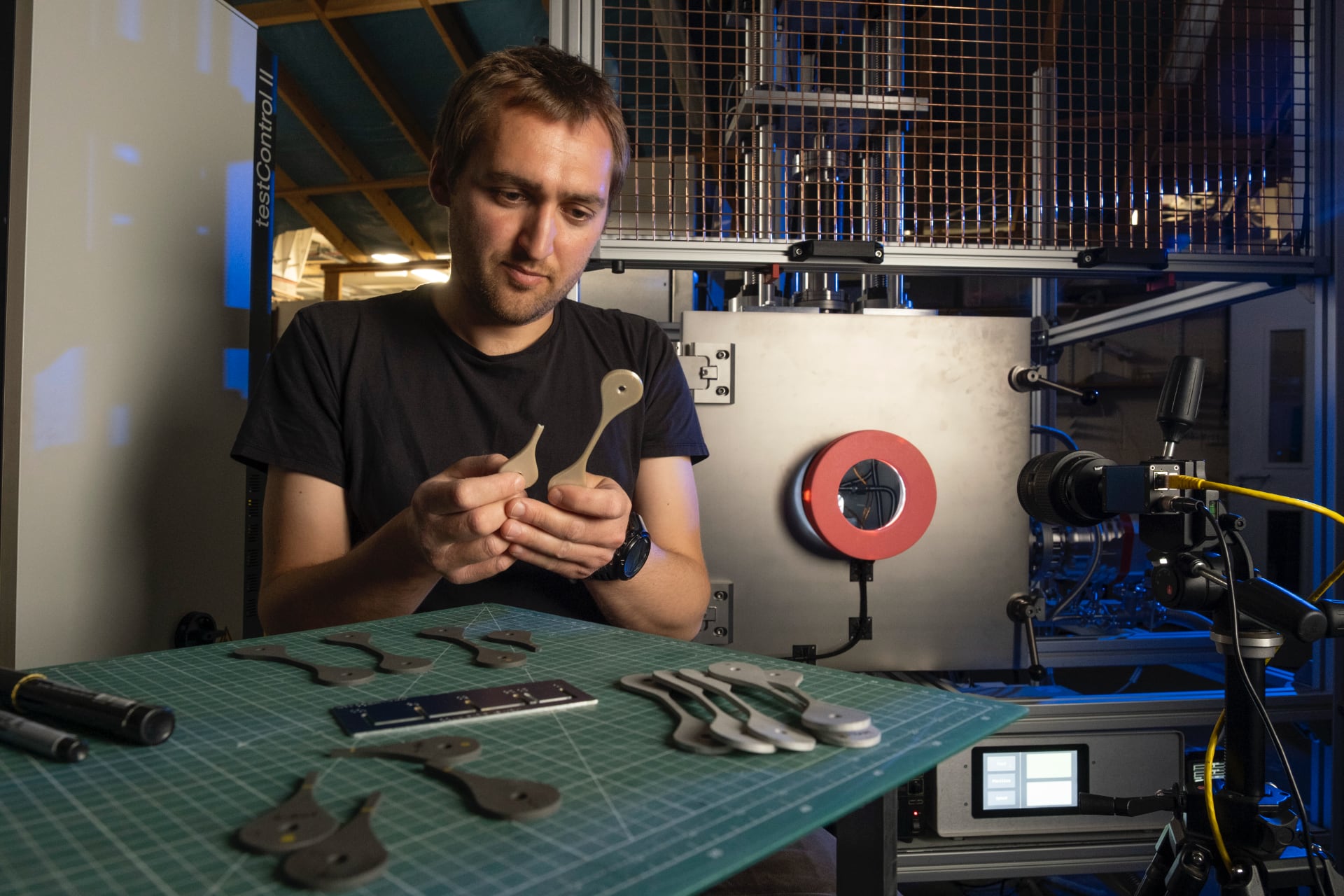 Charlie Patterson examines samples of 3D printed material tested on the NextSpace TestRig