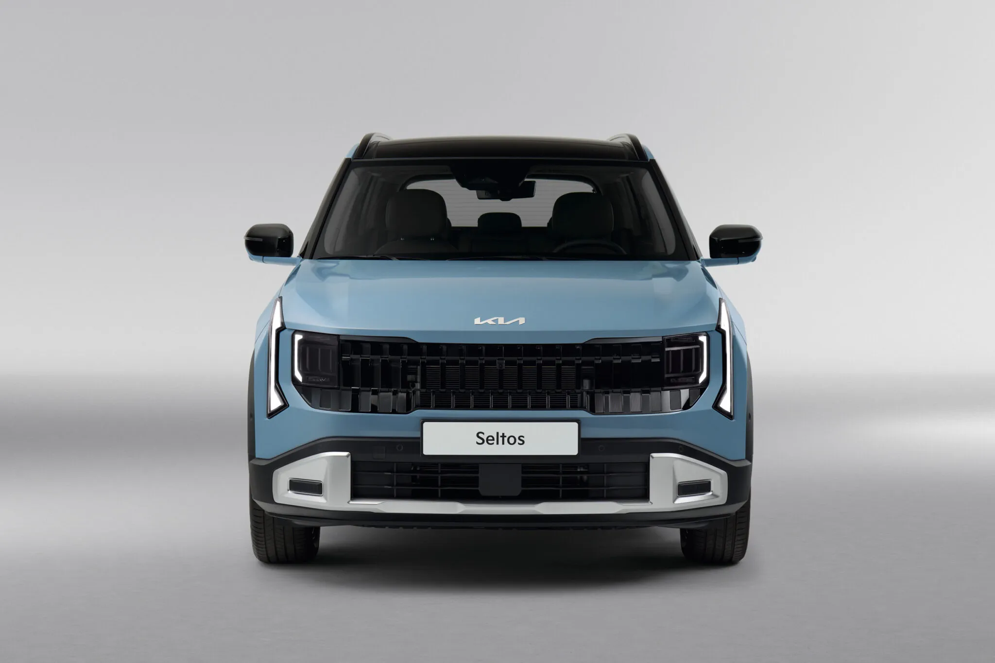 Сріблястий новий Kia Seltos на фоні сучасного міського пейзажу