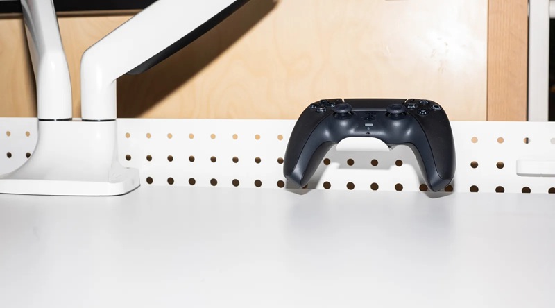 La façade perforée en métal permet de fixer des accessoires gaming modulaires à l'arrière du bureau.