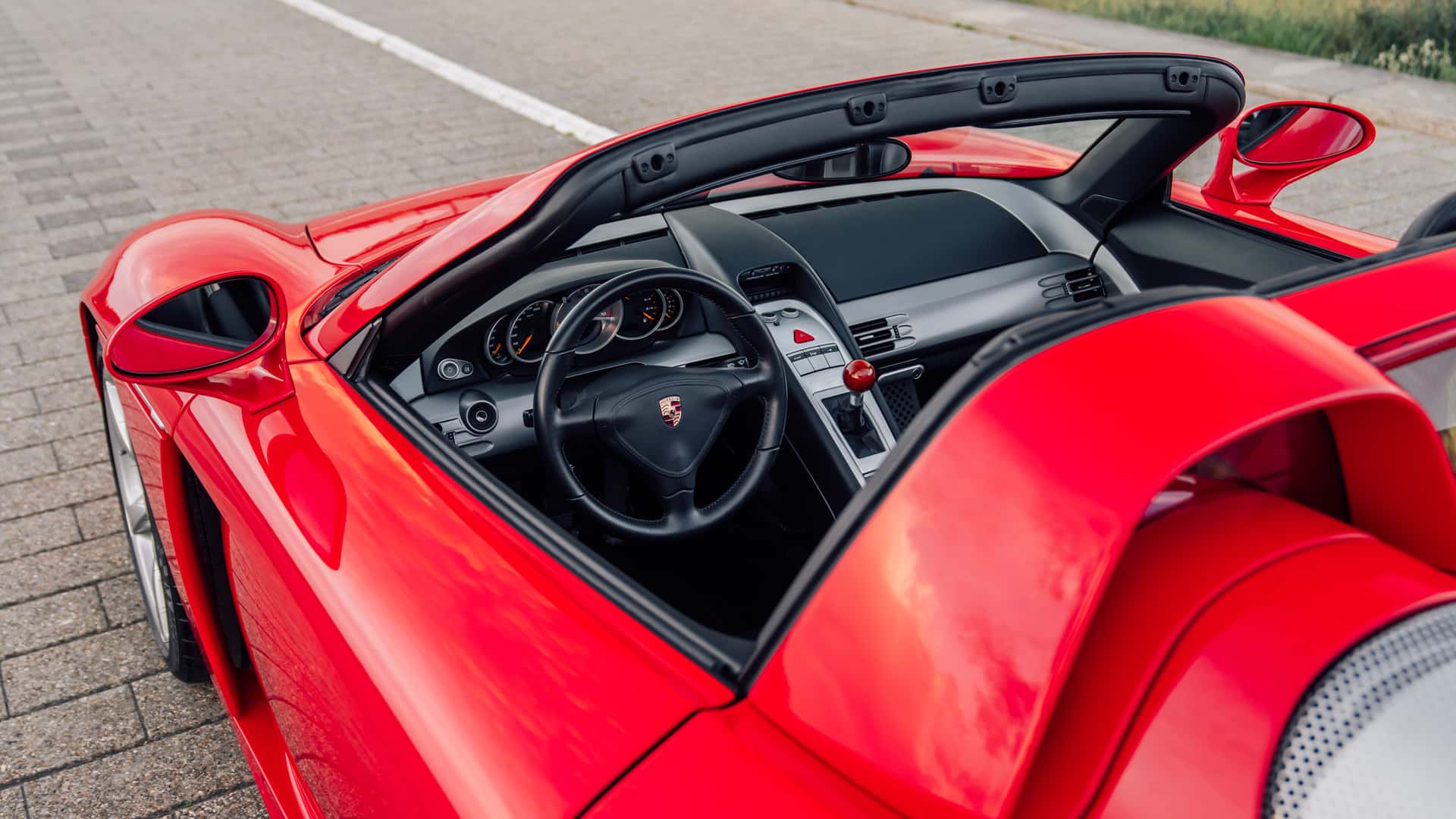 Side mirror view of Porsche Carrera GT in Guards Red